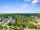 Aerial view of a neighborhood, golf course, and ponds in a serene, community setting at 18209 Breland Dr, Hudson, FL 34667