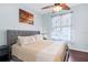 Comfortable bedroom featuring a ceiling fan and a large window with decorative curtains at 18209 Breland Dr, Hudson, FL 34667