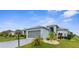 Charming single-story home with a gray roof, two-car garage, well-maintained landscaping, and covered entry at 18209 Breland Dr, Hudson, FL 34667