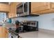 Close-up of the kitchen features light wood cabinets, granite countertops, stainless steel appliances and modern fixtures at 18209 Breland Dr, Hudson, FL 34667