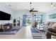 Bright living room features tile flooring, ceiling fan, and sliding doors to the lanai at 18209 Breland Dr, Hudson, FL 34667