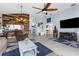 Living room with ceiling fan, tile flooring, and rustic accent wall detail at 18209 Breland Dr, Hudson, FL 34667