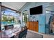 Enclosed patio with a dining table, refrigerator, and a view of the pool and backyard at 18209 Breland Dr, Hudson, FL 34667
