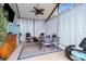 Enclosed patio with curtains, dining table, ceiling fan, and an inviting seating area at 18209 Breland Dr, Hudson, FL 34667