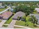 Aerial view of a home with a well-manicured lawn and brick driveway at 18532 Myrtlewood Dr, Hudson, FL 34667
