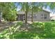 Back exterior view of house with landscaped yard and screened lanai at 18532 Myrtlewood Dr, Hudson, FL 34667