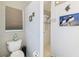 Clean bathroom with a toilet, shower, and decorative artwork at 18532 Myrtlewood Dr, Hudson, FL 34667