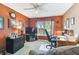 Bedroom with a ceiling fan, window, and cozy seating area with TV and computer at 18532 Myrtlewood Dr, Hudson, FL 34667
