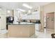 Well-lit kitchen with white cabinets, an island and a black refrigerator at 18532 Myrtlewood Dr, Hudson, FL 34667