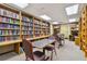 Cozy library space with extensive bookshelves, tables, and chairs for reading and studying at 18532 Myrtlewood Dr, Hudson, FL 34667