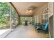 Screened patio with ceiling fan and furniture, overlooking landscaped backyard at 18532 Myrtlewood Dr, Hudson, FL 34667