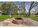 A paver patio with an outdoor fire pit and seating in a verdant backyard at 18620 Gracie Lee St, Spring Hill, FL 34610