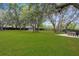 Sprawling backyard with mature trees, fire pit and outdoor seating area at 18620 Gracie Lee St, Spring Hill, FL 34610