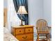 Lovely bedroom detail highlighting the nightstand, lamp, and chair at 18620 Gracie Lee St, Spring Hill, FL 34610