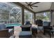 Inviting covered patio area with comfortable seating, a fire pit, and a view of the sparkling pool at 18620 Gracie Lee St, Spring Hill, FL 34610