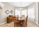 Charming dining room with hardwood table, chairs, and bright, sheer-curtained windows at 18620 Gracie Lee St, Spring Hill, FL 34610
