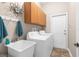 Functional laundry room with washer, dryer, utility sink, and cabinet storage space at 18620 Gracie Lee St, Spring Hill, FL 34610