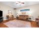Spacious living room features a ceiling fan, plush seating, and an area rug on hardwood flooring at 18620 Gracie Lee St, Spring Hill, FL 34610