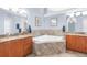 Spa-like main bathroom featuring a corner soaking tub, dual vanities, and tile accents at 18620 Gracie Lee St, Spring Hill, FL 34610