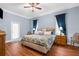Relaxing main bedroom featuring a plush bed, soft lighting, and calming blue walls at 18620 Gracie Lee St, Spring Hill, FL 34610