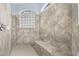 Walk-in shower showcasing custom tile design, built-in bench, showerhead and glass block window at 18620 Gracie Lee St, Spring Hill, FL 34610