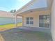 A covered back patio extends from the home, featuring neutral paint and an exit door to the backyard at 19855 Ellendale Dr, Land O Lakes, FL 34638