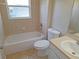 Well-lit bathroom featuring a tub with tile surround, toilet, and vanity with a sink at 19855 Ellendale Dr, Land O Lakes, FL 34638