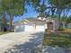 Charming single-story home with a three-car garage and well-maintained landscaping, under a bright blue sky at 19855 Ellendale Dr, Land O Lakes, FL 34638