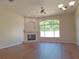 Comfortable living room with vinyl wood floors, neutral paint, a tiled fireplace, and natural light from a window at 19855 Ellendale Dr, Land O Lakes, FL 34638