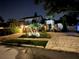Nighttime view of a two-story home featuring stone accents, exterior lighting, and a brick paver driveway at 210 S Hale Ave, Tampa, FL 33609