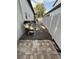 Side yard area with brick pavers transitioning to gravel and a white vinyl fence at 210 S Hale Ave, Tampa, FL 33609