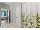Bathroom with a decorative shower curtain, linen storage, and access to the main bedroom at 21167 Pleasant Plains Pkwy, Land O Lakes, FL 34637