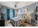 Stylish bedroom with hardwood floors, decorative blue curtains, and cozy bedding creating a serene retreat at 21167 Pleasant Plains Pkwy, Land O Lakes, FL 34637