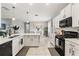 Modern kitchen features white cabinets, quartz countertops, stainless steel appliances, and an island with a sink at 21167 Pleasant Plains Pkwy, Land O Lakes, FL 34637