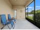 Relaxing screened porch featuring blue outdoor chairs and views of the backyard at 21167 Pleasant Plains Pkwy, Land O Lakes, FL 34637