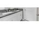 Bathroom featuring double vanity with granite countertops, white cabinetry and modern fixtures at 2132 Shining Azul Way, Lutz, FL 33558