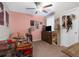 Cozy bedroom with pink walls, a ceiling fan, and personal decorations at 2132 Shining Azul Way, Lutz, FL 33558