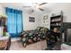 Whimsical bedroom with blue curtains, ceiling fan, decorative shelving, and unique personal touches at 2132 Shining Azul Way, Lutz, FL 33558