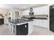 Modern kitchen with a large island, seating, granite countertops, white cabinets, and stainless steel appliances at 2132 Shining Azul Way, Lutz, FL 33558