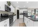 Bright kitchen features stainless steel appliances, granite countertops, white cabinets and a large island with seating at 2132 Shining Azul Way, Lutz, FL 33558