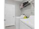 A functional laundry room equipped with a washing machine, dryer, and wire shelving for organized storage at 2132 Shining Azul Way, Lutz, FL 33558