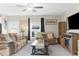 Bright living room featuring a ceiling fan, comfortable seating, neutral tones, large windows, and stylish décor at 2132 Shining Azul Way, Lutz, FL 33558