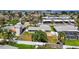 Aerial view of property showcasing fenced yard, wooden deck, lush landscaping, and location near the water at 2175 Edythe Dr, Dunedin, FL 34698