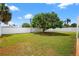 Spacious backyard featuring mature trees and a well-maintained white privacy fence at 2175 Edythe Dr, Dunedin, FL 34698