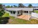 The exterior of a home's backyard, featuring a wooden deck and privacy fence at 2175 Edythe Dr, Dunedin, FL 34698