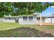 View of the back of house with an outdoor wooden deck and leafy trees at 2175 Edythe Dr, Dunedin, FL 34698