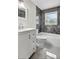 Well-lit bathroom with granite tile, soaking tub, and white vanity at 2175 Edythe Dr, Dunedin, FL 34698