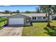Home boasts charming curb appeal with a well-manicured lawn and mature landscaping at 2175 Edythe Dr, Dunedin, FL 34698