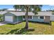 Charming single-story home featuring a well-manicured lawn and beautiful stone accents at 2175 Edythe Dr, Dunedin, FL 34698