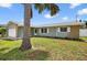 Charming single Gathering home features stone accents, lush green lawn, and mature landscaping at 2175 Edythe Dr, Dunedin, FL 34698